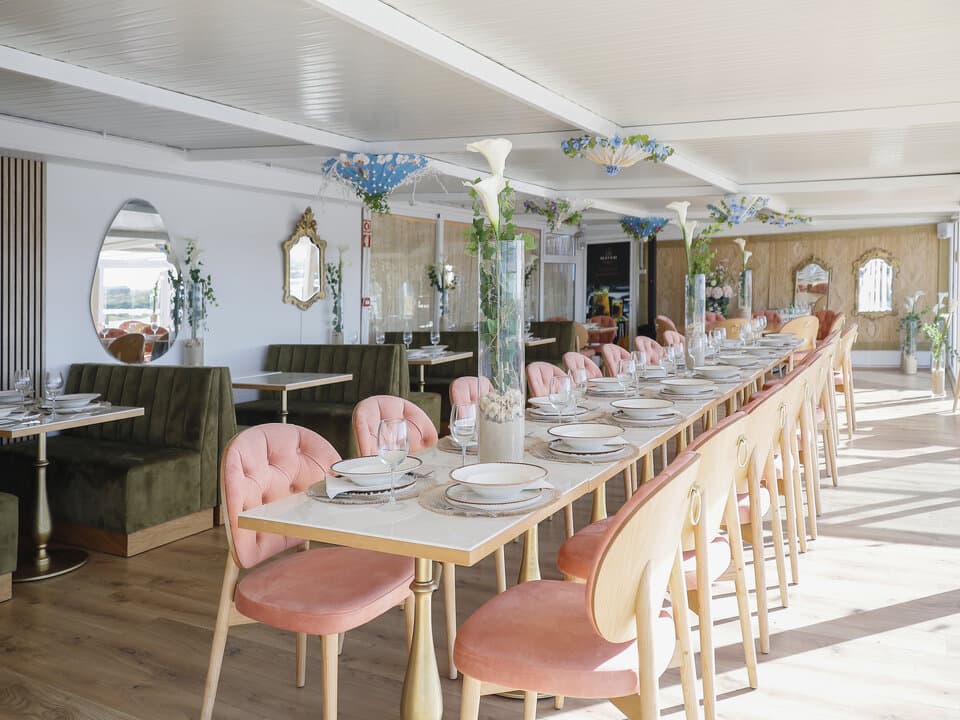 Sala interior do restaurante, mesas em madeira, luz quente